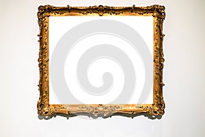 Old ornamental golden picture frame on gray wall