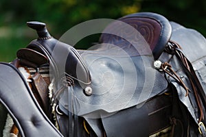 Old ornamental saddle on the wooden fence