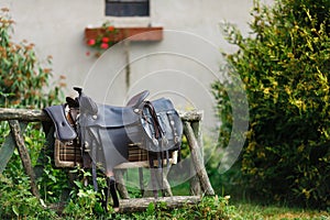 Old ornamental saddle on the wooden fence