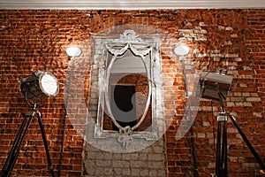 Old ornate frames on mirror glas hanging a brick wall.