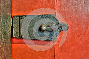 Old ornate metal lock on red door