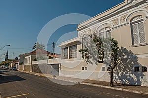 Old ornate townhouse in an empty street with trees on sidewalk in a sunny day at San Manuel.