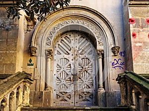 Old ornate wooden door of a ruined church in El Raval, Barcelona, Catalonia, Spain