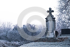 Old Orthodox cross tombstone in forest as scary Helloween cemetery