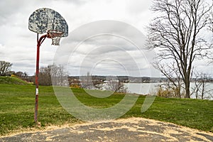 Old outdoor baskeball hoop with the broken wooden backboard in a park in Portland Maine.