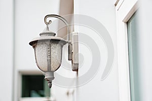 Old outdoor wall lamp light on white exterior