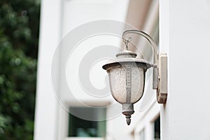 Old outdoor wall lamp light on white exterior