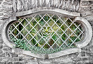 Old oval window with iron bars.