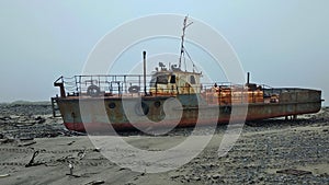 An old ownerless ship rusting in the arctic tundra on the shores of the Barents Sea. Varandey