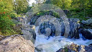 The old packhorse bridge known as Birk`s Bridge across the river Duddon near Seathwaite in the Lake District National Park