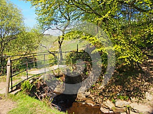 The old packhorse bridge at lumb hole falls a waterfall in woodland at crimsworth dean near pecket well in calderdale west