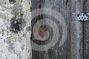 An old padlock on a gray stripped wooden gate. Protect property and privacy. Close-up