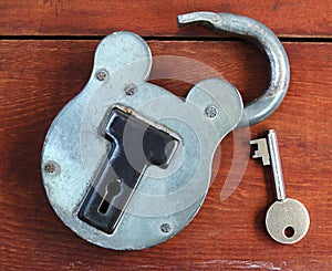 Old padlock and key on wood background