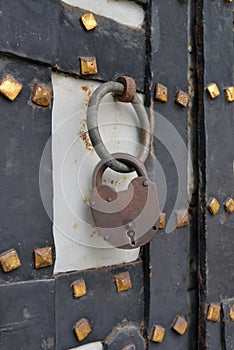 The old padlock lock hangs on a gate
