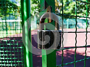 Old padlock on the net fence gate