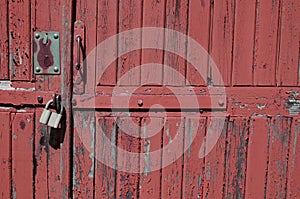 Old padlock on rustic red wooden door