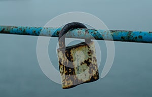 Old padlock. Vintage lock on the railing. Closed padlock. Iron fittings.