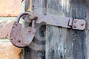 An old rusty padlock for closing ranch doors.