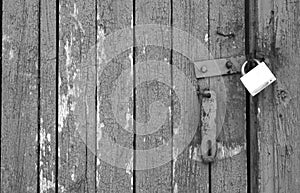 Old padlock on wooden gate in black and white