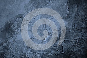 Old painted concrete wall surface. Close-up. Gray blue color. Rough dark background.