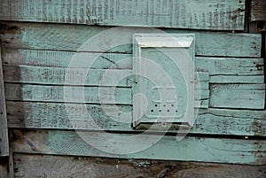 Old painted mail box on a wooden green wall