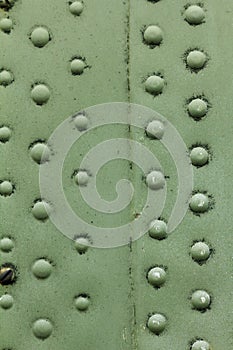 Old painted metal background detail of a military aircraft, surface corrosion.