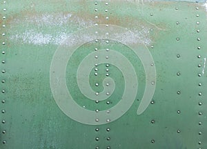 Old painted metal background detail of a military aircraft, surface corrosion.