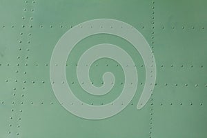 Old painted metal background detail of a military aircraft, surface corrosion.