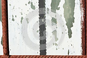 Old painted window behind iron bar. Grunge background