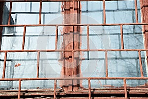 Old painted window behind rusty grate