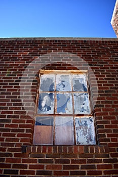 Old Painted Windows in a Brick Building Under Blue Sky