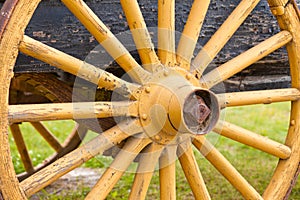 Old painted yellow wagon wheel on historic cart