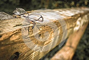 Old pair of spectacles with missing lens, left on a gate post