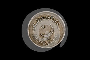 An old Pakistani five rupee coin isolated on black