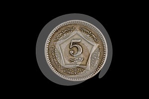 An old Pakistani five rupee coin isolated on black