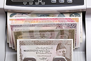 Old Pakistani rupee in a counting machine