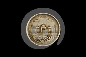 An old Pakistani two rupee coin isolated on black