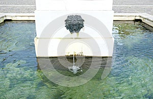 Old Palace garden ancient stone sculptured fountain with falling stream into clean transparent water