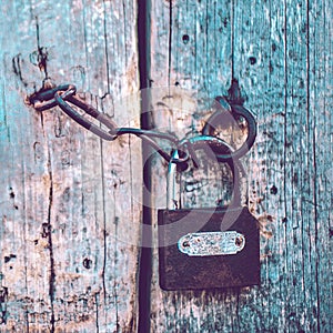 Old pale blue wooden door with a lock and a chain. Boho style