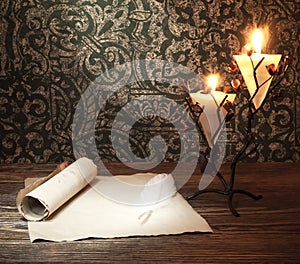 Old paper with a candle and a quill pen