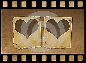 Old paper slides in the form of hearts on grunge background