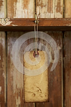 Old paper tag with string hanged on on hook