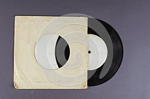 Old paper wrapped vinyl record on gray background