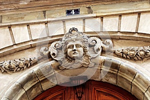 Paris building faÃÂ§ade sculpture woman`s head front entrance photo