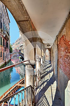 Old passage along canal. Venice, Italy.