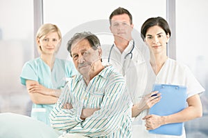 Old patient with doctors and nurse