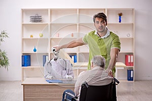 Old patient in wheel-chair visiting skeleton doctor