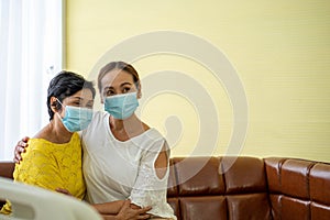Old patient woman  in hospital with daughter taking care with protective face mask.  Health care and medicine concept