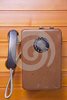 Old pay phone with dial pad on wooden background