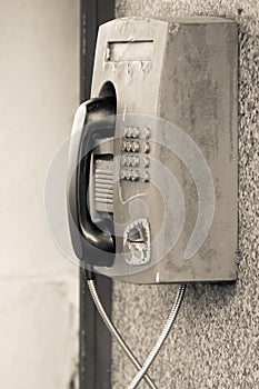 Old payphone closeup and located outdoor on a wall